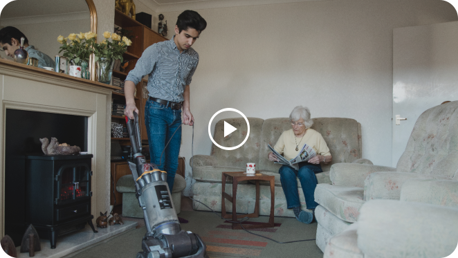 man cleaning on the floor while woman reading a newspaper