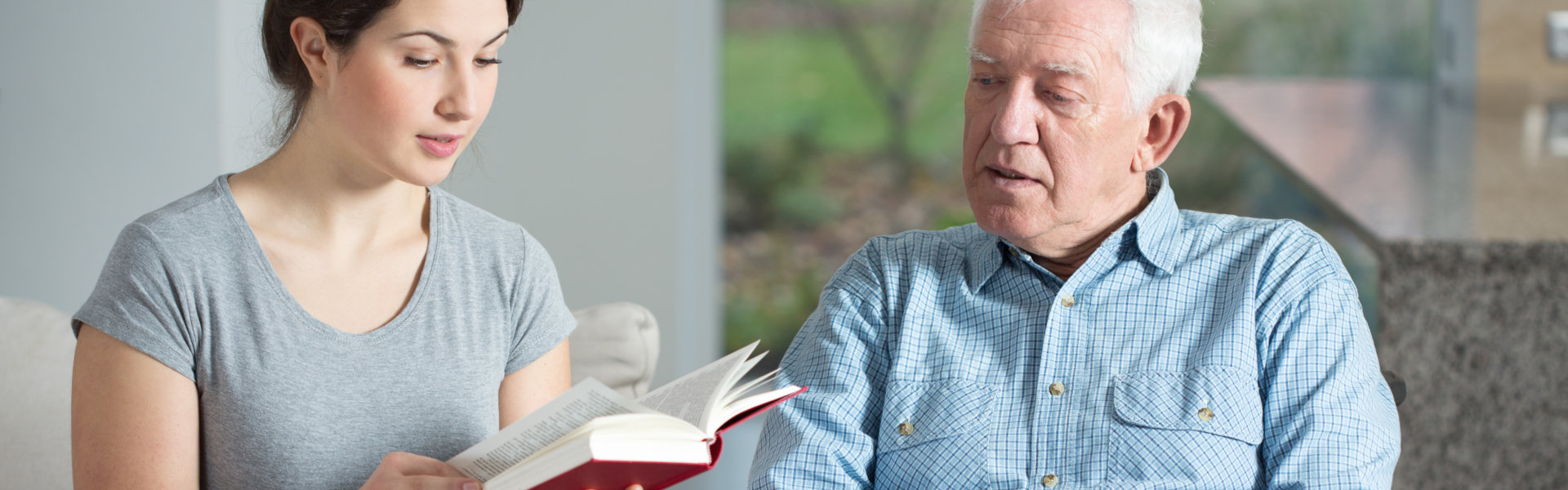 Woman and senior man reading the book