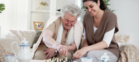 woman and senior woman playing chess