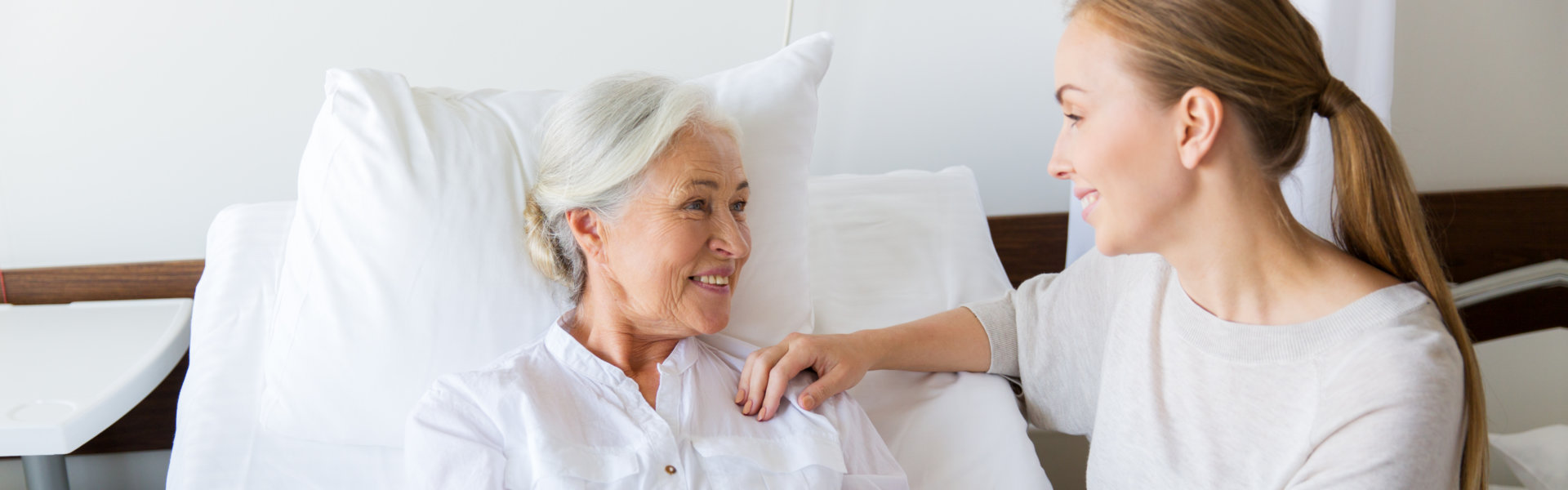 senior woman and woman looking at each other and smiling